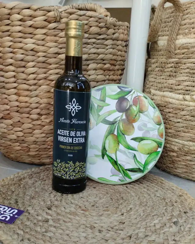 Dark glass bottle of Aceite Herencia, first-day-of-harvest extra virgin olive oil